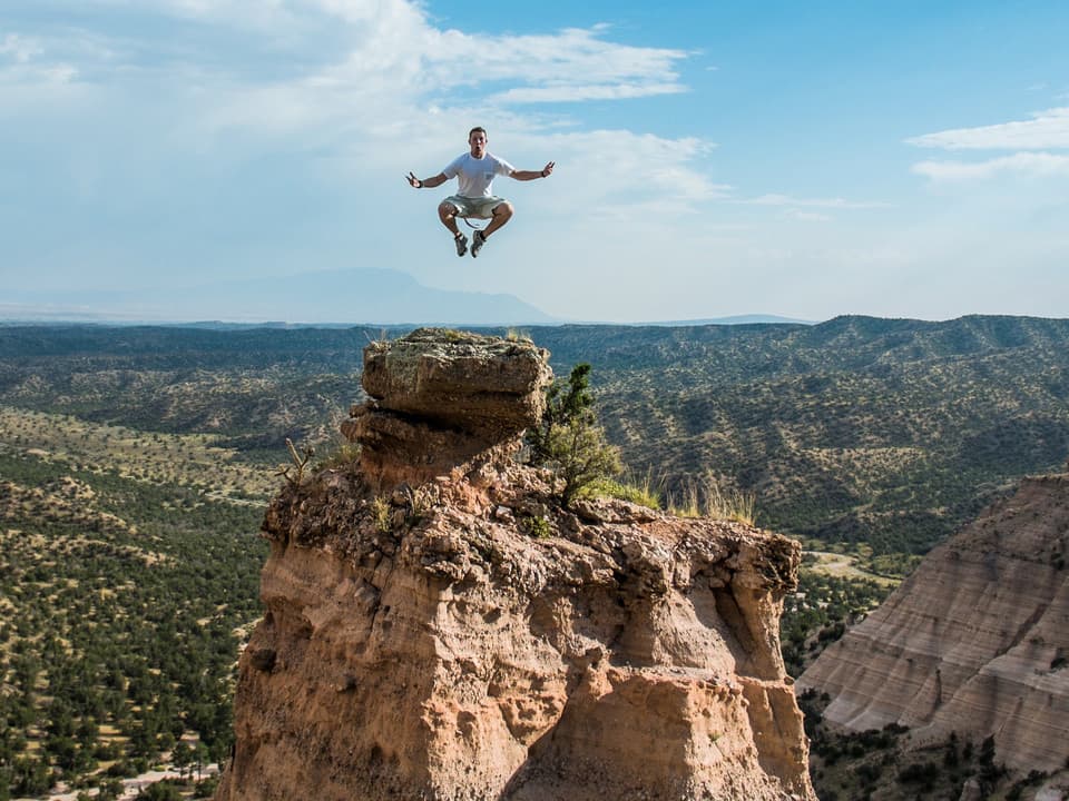 man jumping off a mountain